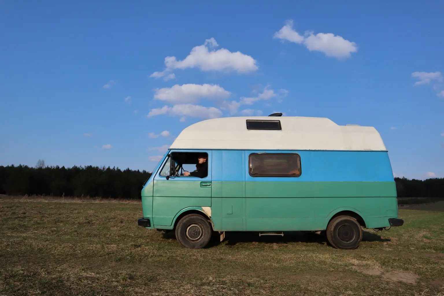 Сине-зелёный VW LT Dos Mezcalitos в поле под летним небом
